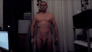 Full frontal image of a naked man standing in a room, facing the camera with a neutral expression.