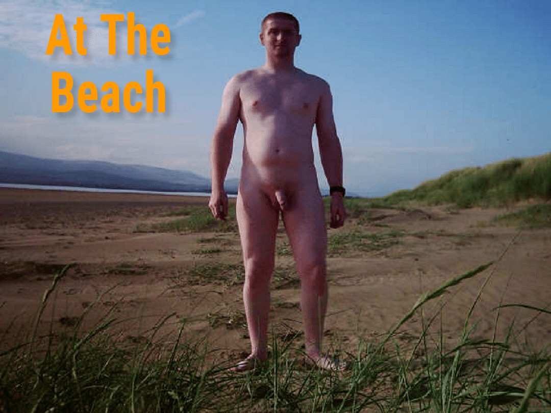 A man stands confidently on a sandy beach, surrounded by lush green grass and distant hills under a bright blue sky. The sun casts a warm glow on his bare skin, highlighting his natural pose, as he enjoys the serene beach atmosphere.